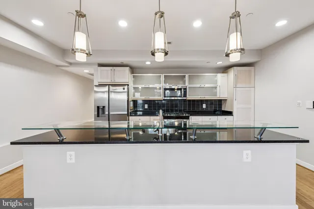 a kitchen with stainless steel appliances granite countertop a sink a stove and a refrigerator