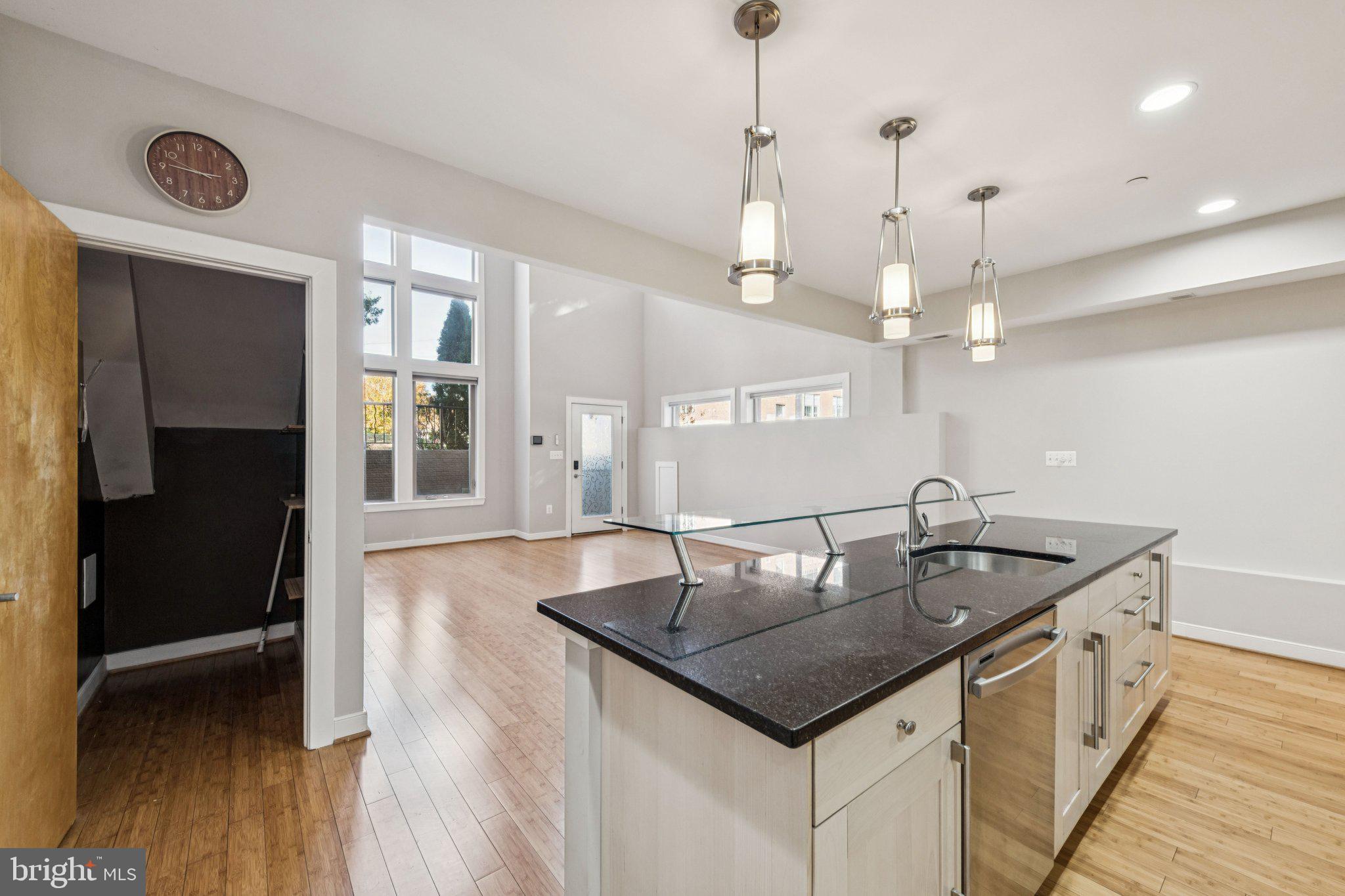 241 R Street Northeast, Unit A Washington, DC 20002 - Photo 7 of 33 a kitchen with stainless steel appliances granite countertop a sink a counter space and wooden floor