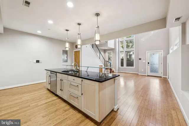 a view of a livingroom with wooden floor and stairs