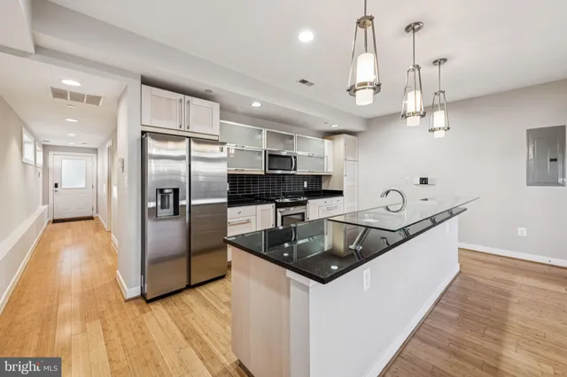 a kitchen with stainless steel appliances granite countertop a sink a stove and a refrigerator