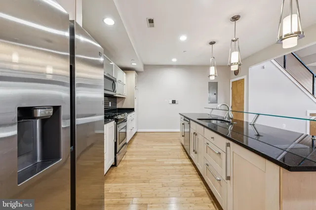 a large kitchen with stainless steel appliances kitchen island a large counter top