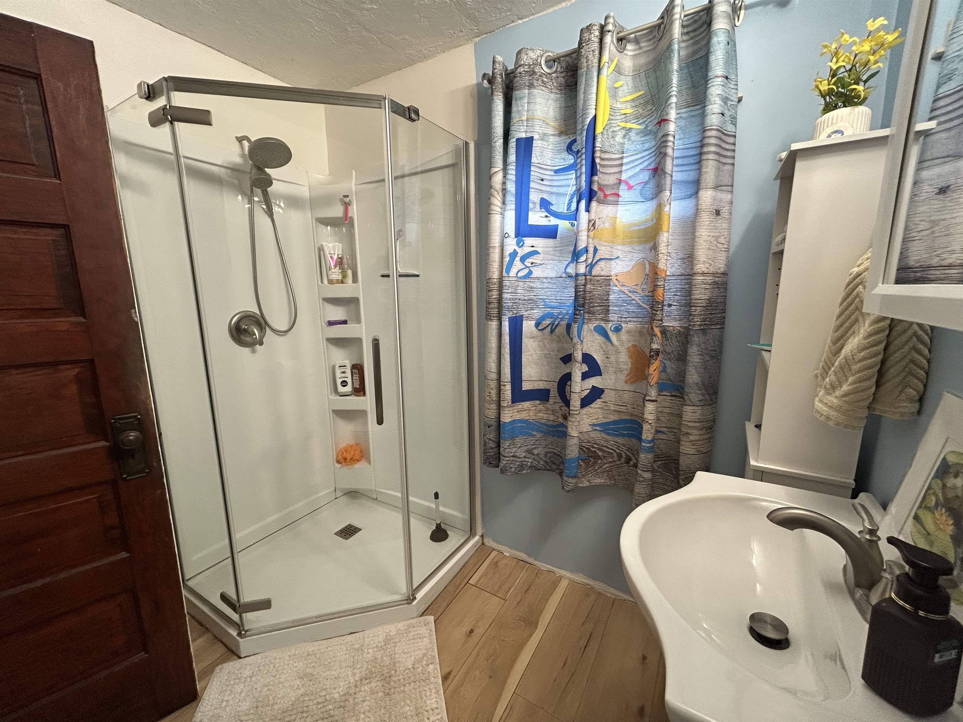 910 North 20th Street Superior, WI 54880 - Photo 14 of 39 Full bath with wood finished floors, a stall shower, and a textured ceiling