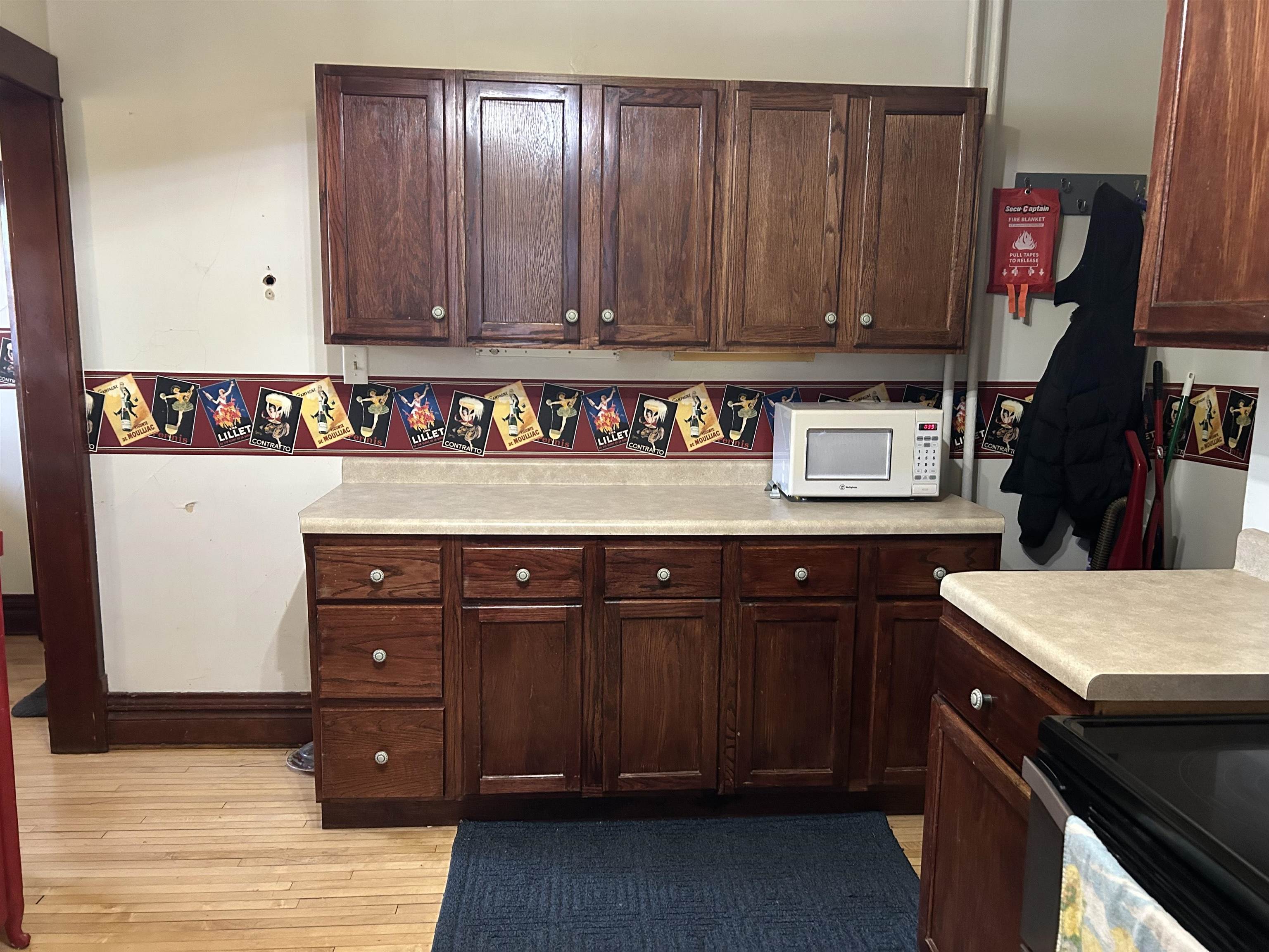 910 North 20th Street Superior, WI 54880 - Photo 31 of 39 Kitchen featuring light countertops, white microwave, light wood-style flooring, stainless steel electric range, and dark brown cabinetry