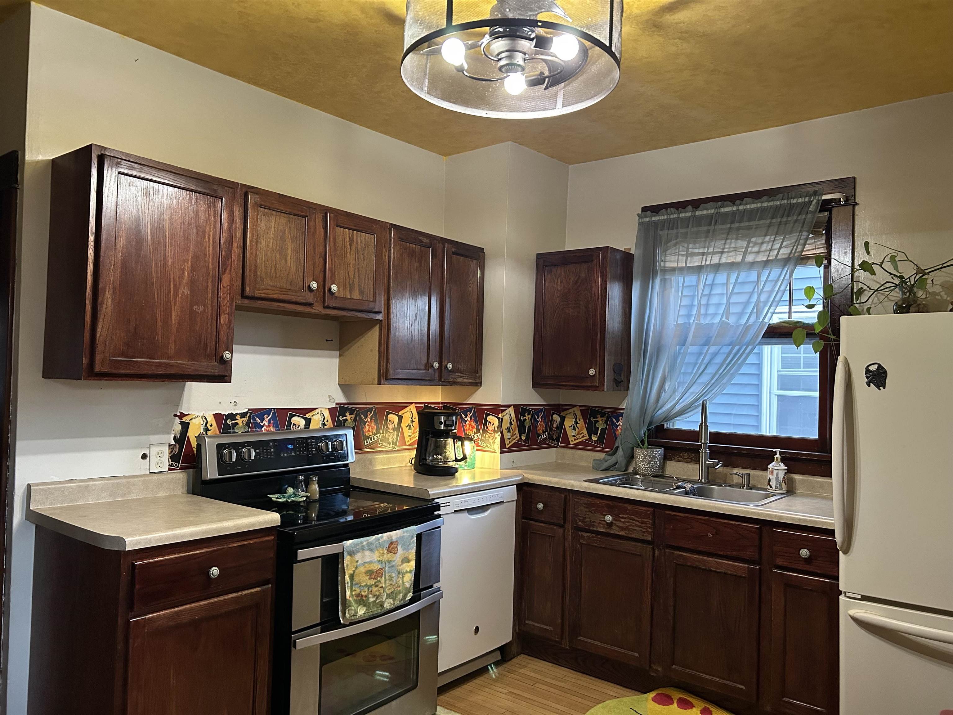 910 North 20th Street Superior, WI 54880 - Photo 35 of 39 Kitchen with white appliances, dark brown cabinetry, light countertops, and light wood-type flooring