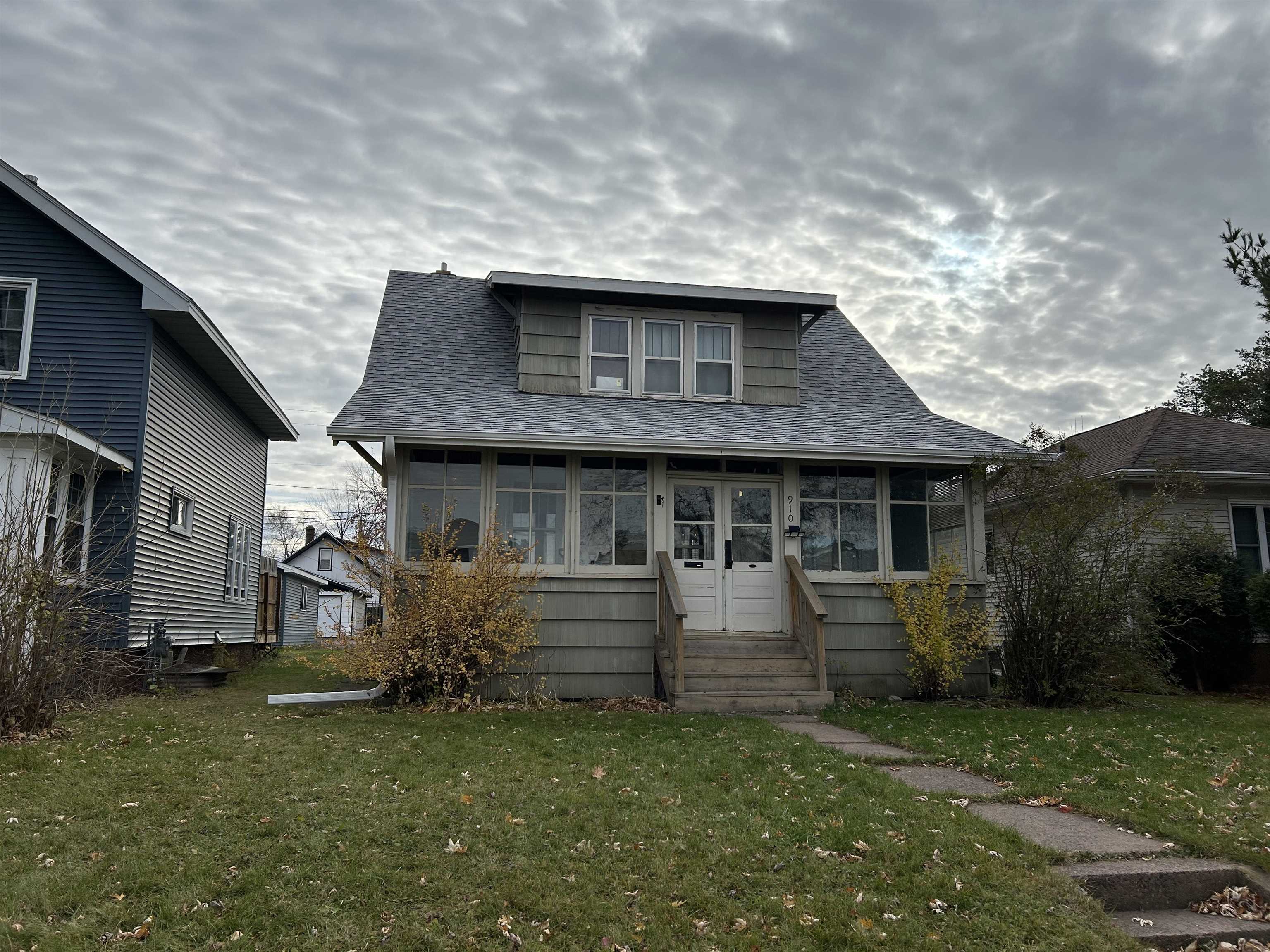 910 North 20th Street Superior, WI 54880 - Photo 4 of 39 Bungalow with a sunroom, roof with shingles, and a front yard