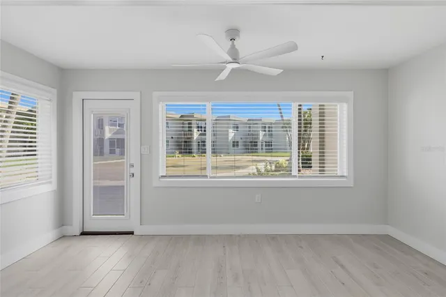 a view of an empty room with a window and wooden floor