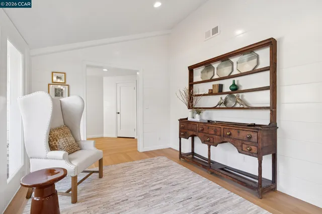 a view of a yard with plants and a bench in the background