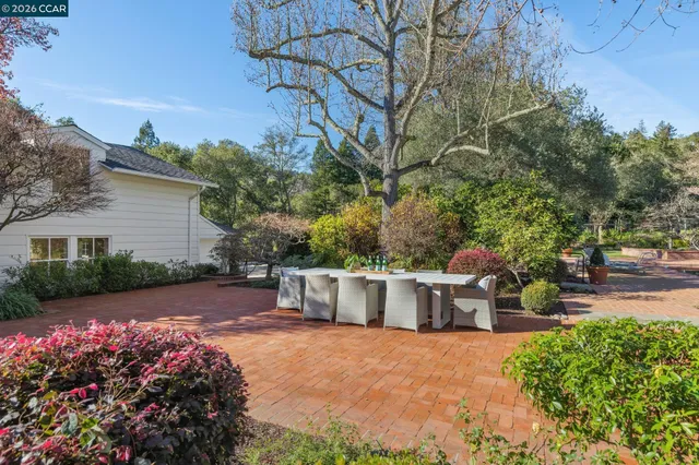 a living room with furniture kitchen view and a chandelier
