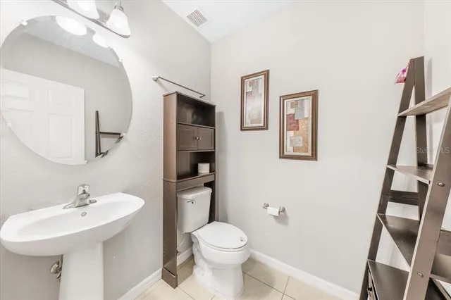 a kitchen with stainless steel appliances kitchen island granite countertop a sink a stove a microwave oven a refrigerator with island and chairs with wooden floor