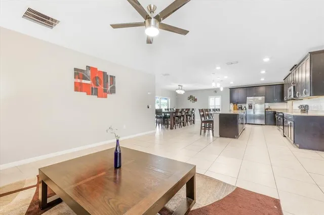 a living room with couches and a ceiling fan