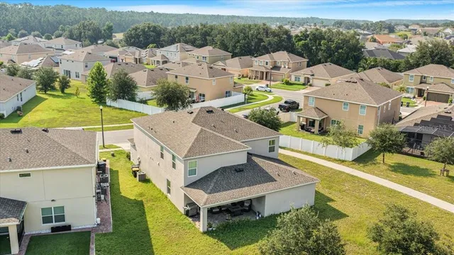 an aerial view of residential houses with yard