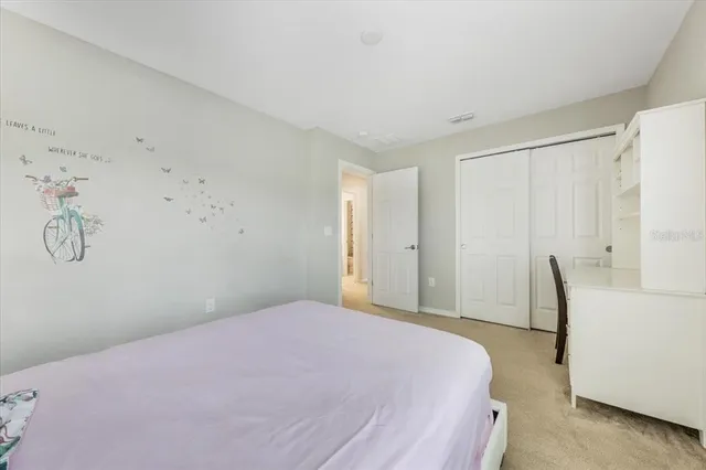 a bedroom with a bed and a lamp on dresser