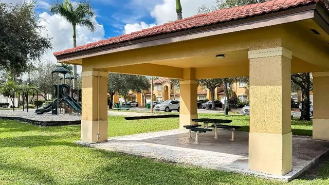 a view of a swimming pool with a patio and a yard