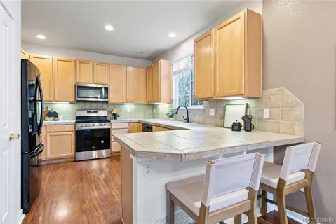 a kitchen with a stove a sink a microwave and a refrigerator