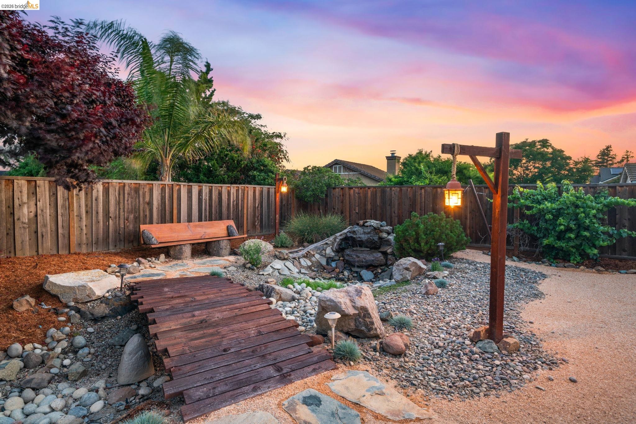1186 El Rio Court Livermore, CA 94551 - Photo 37 of 60 Landscaped backyard featuring a decorative wooden bridge, a rock garden, and a built-in waterfall feature