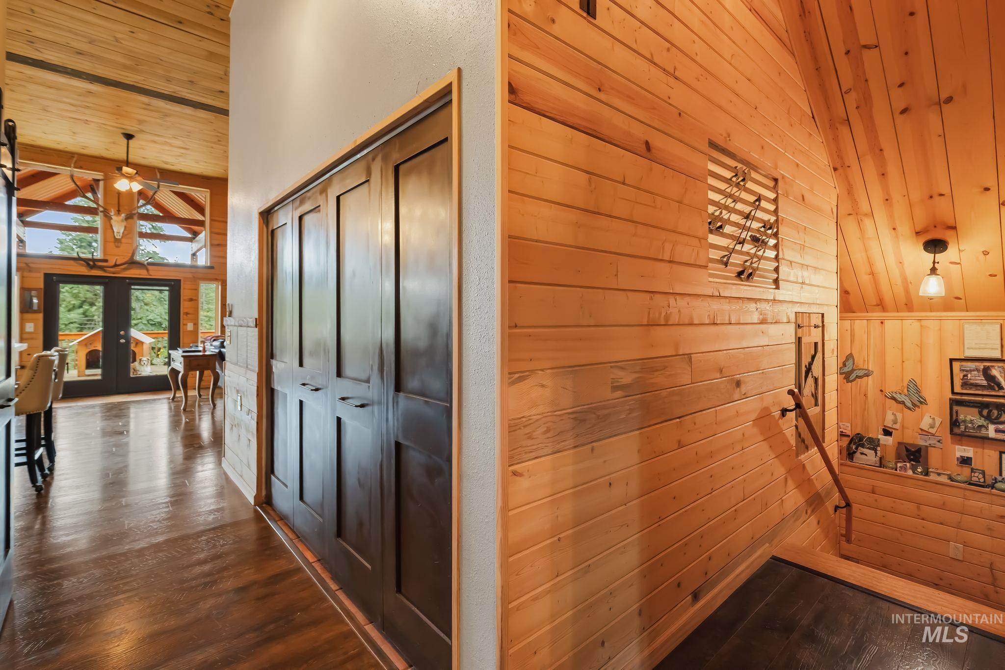 3989 East Mountain Road Anatone, WA 99401 - Photo 6 of 49 Wood-finish flooring, dark paneled bi-fold doors, wood plank accent wall, and wood plank ceiling