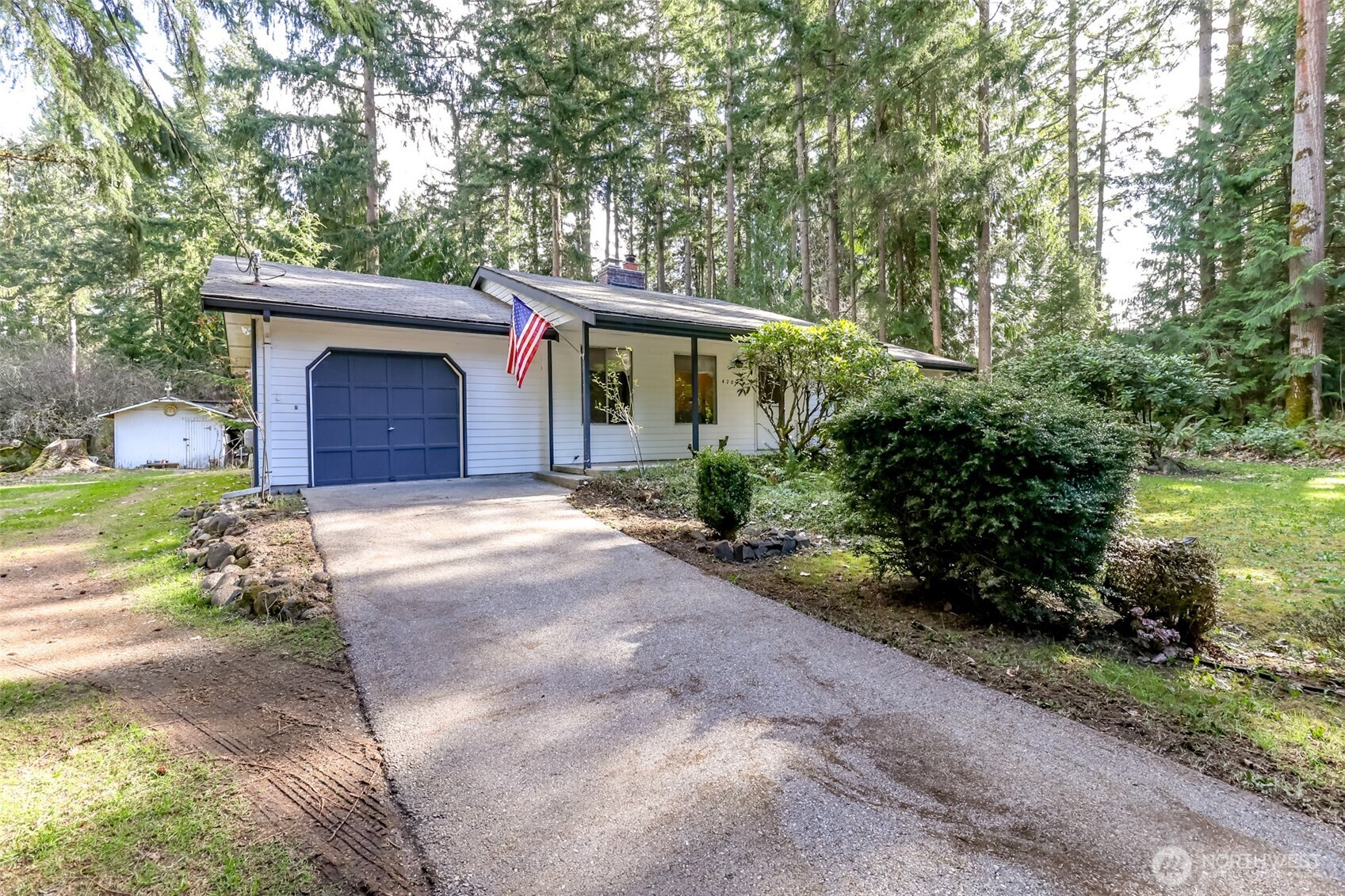 4701 292nd Street East Graham, WA 98338 - Photo 3 of 40 a front view of a house with a garden and trees