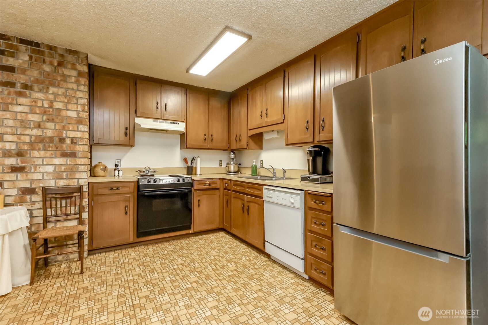 4701 292nd Street East Graham, WA 98338 - Photo 10 of 40 a kitchen with granite countertop stainless steel appliances and wooden cabinets