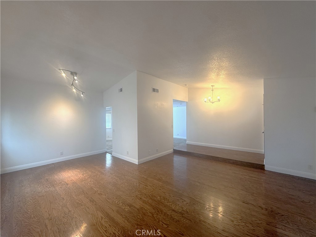 977 Wellington Road San Dimas, CA 91773 - Photo 3 of 20 an empty room with wooden floor and windows