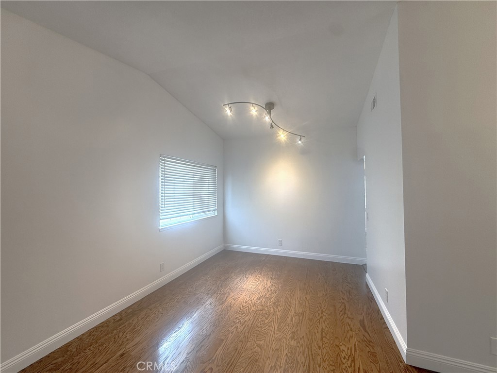 977 Wellington Road San Dimas, CA 91773 - Photo 5 of 20 an empty room with wooden floor and windows
