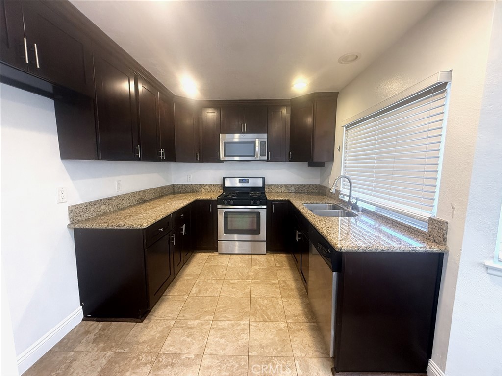 977 Wellington Road San Dimas, CA 91773 - Photo 6 of 20 a kitchen with stainless steel appliances granite countertop a sink a stove and a refrigerator
