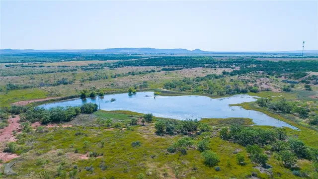 an aerial view of a houses with a yard and lake view
