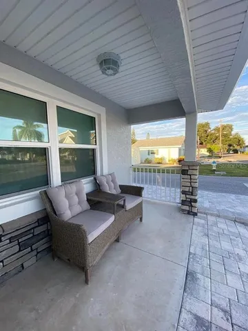 a living room with patio furniture and a floor to ceiling window
