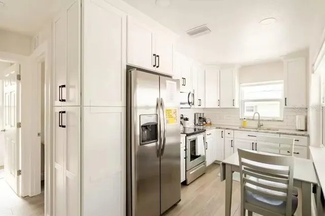 a kitchen with stainless steel appliances a refrigerator sink and cabinets