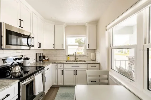 a kitchen with a sink stove top oven and cabinets