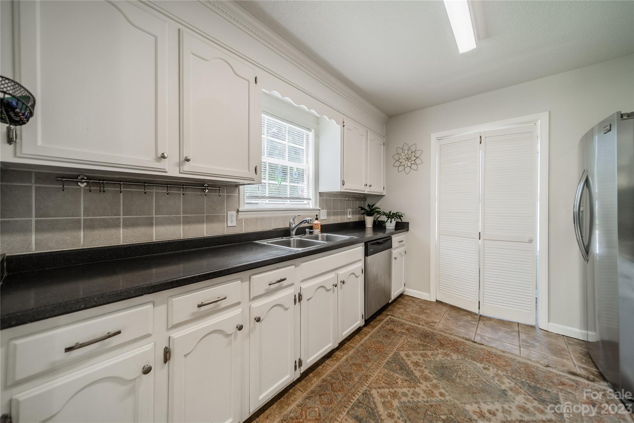 1585 Wimbleton Woods Drive Fort Mill, SC 29708 - Photo 19 of 41 a kitchen with granite countertop white cabinets and window