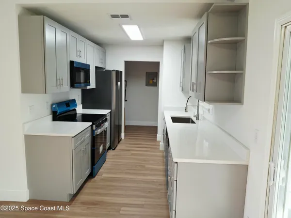 a kitchen with a sink a refrigerator and cabinets
