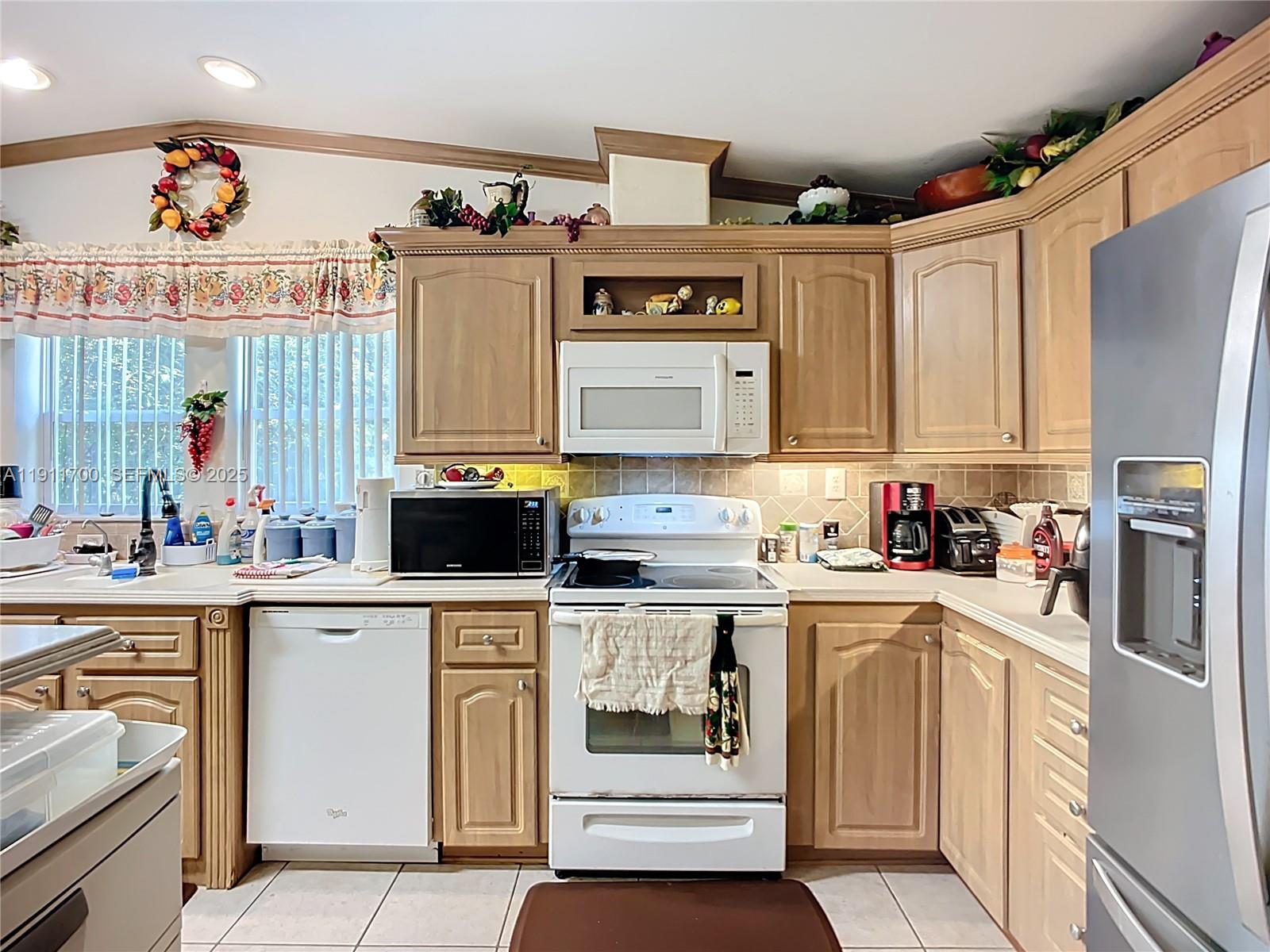 1432 Silver Lake Road LaBelle, FL 33935 - Photo 13 of 39 a kitchen with stainless steel appliances a stove a sink and white cabinets