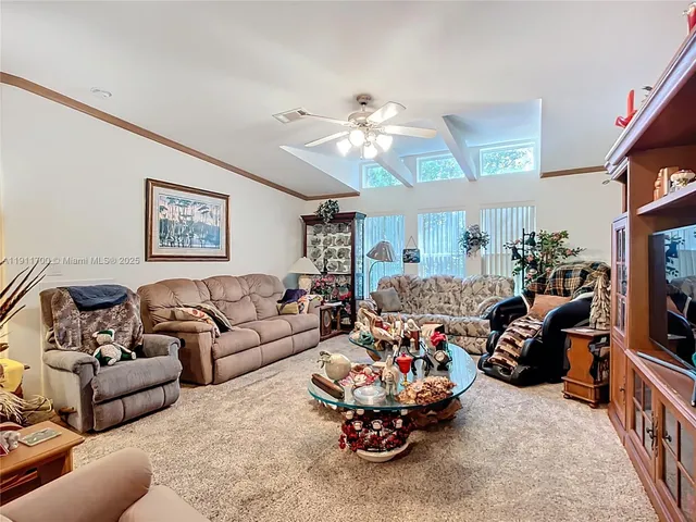 a living room with furniture a chandelier and a flat screen tv
