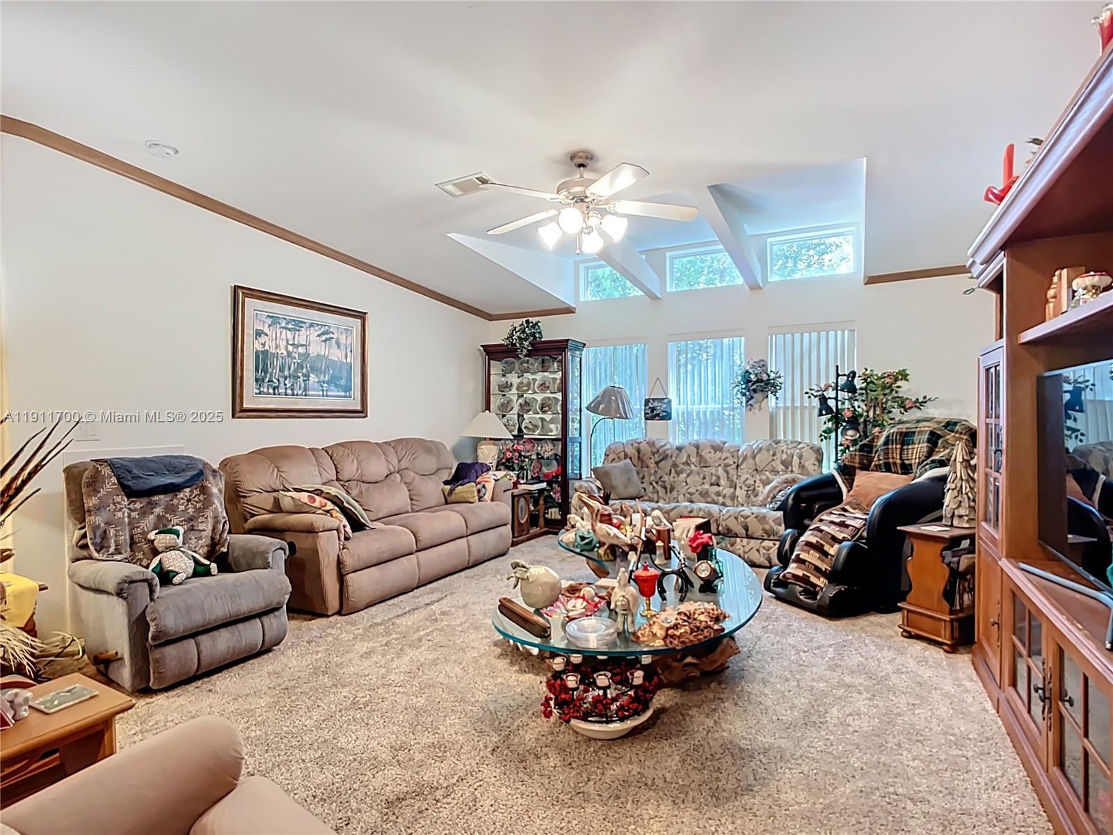 1432 Silver Lake Road LaBelle, FL 33935 - Photo 15 of 39 a living room with furniture a chandelier and a flat screen tv