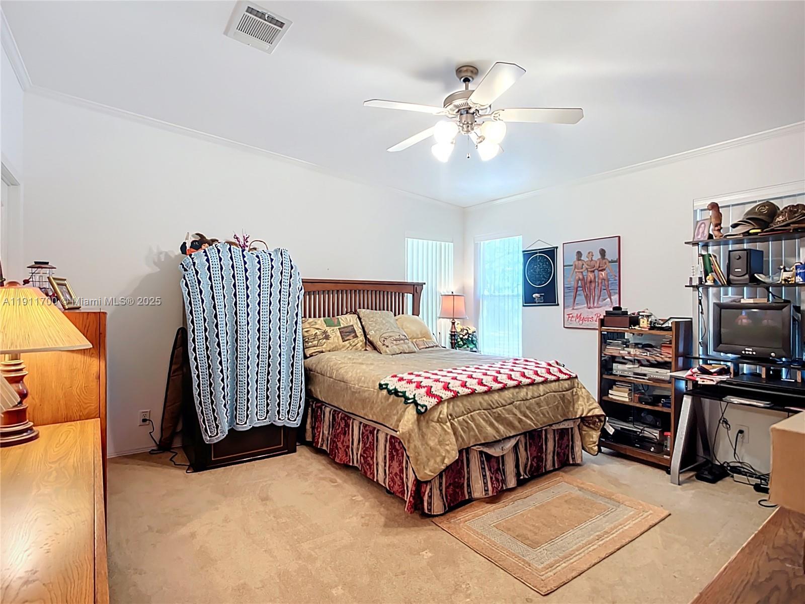 1432 Silver Lake Road LaBelle, FL 33935 - Photo 19 of 39 a bedroom with a bed and a chandelier
