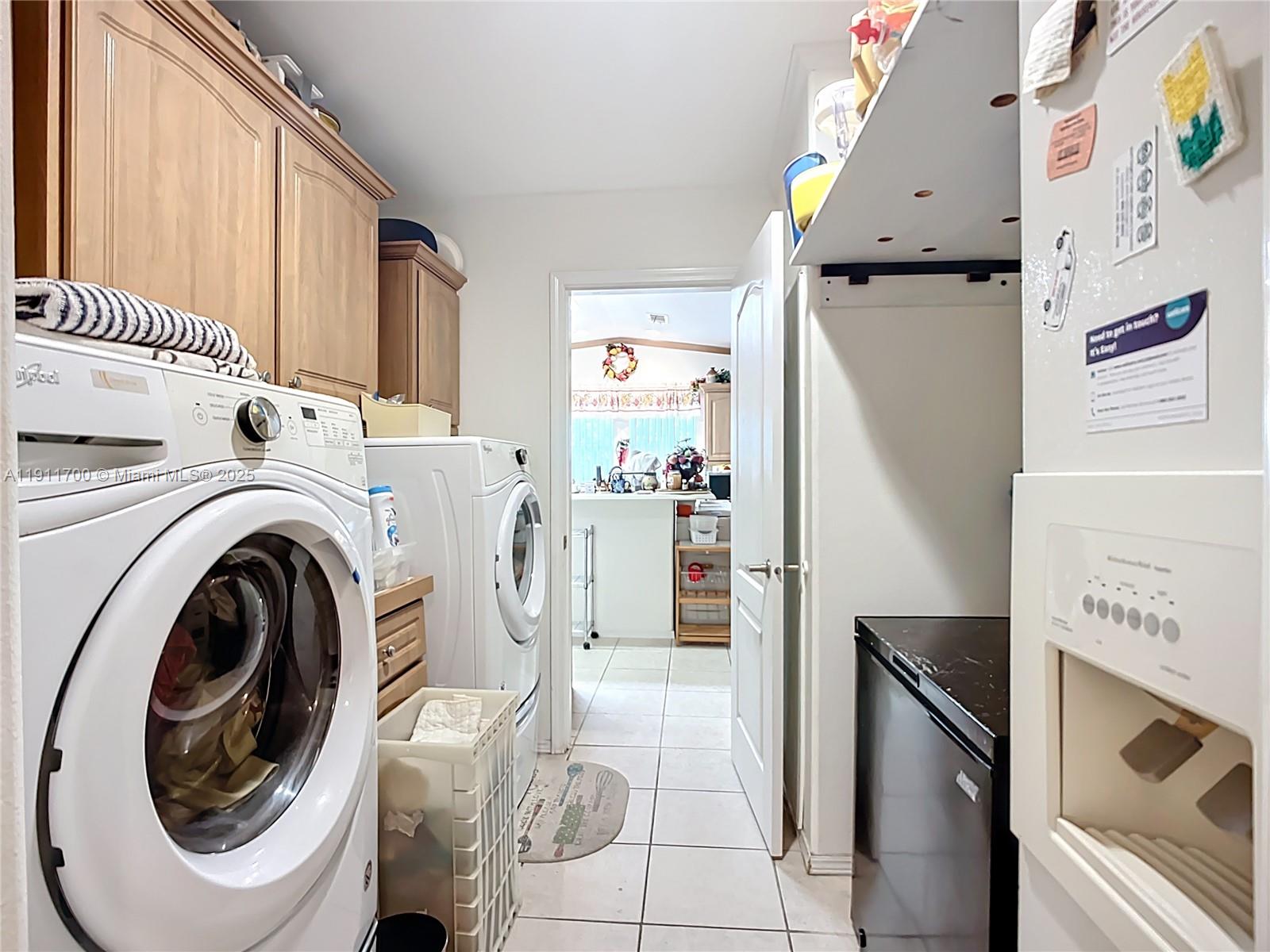 1432 Silver Lake Road LaBelle, FL 33935 - Photo 24 of 39 a view of washer and dryer with kitchen in the background