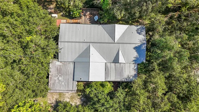 a view of a swimming pool with lawn chairs and plants