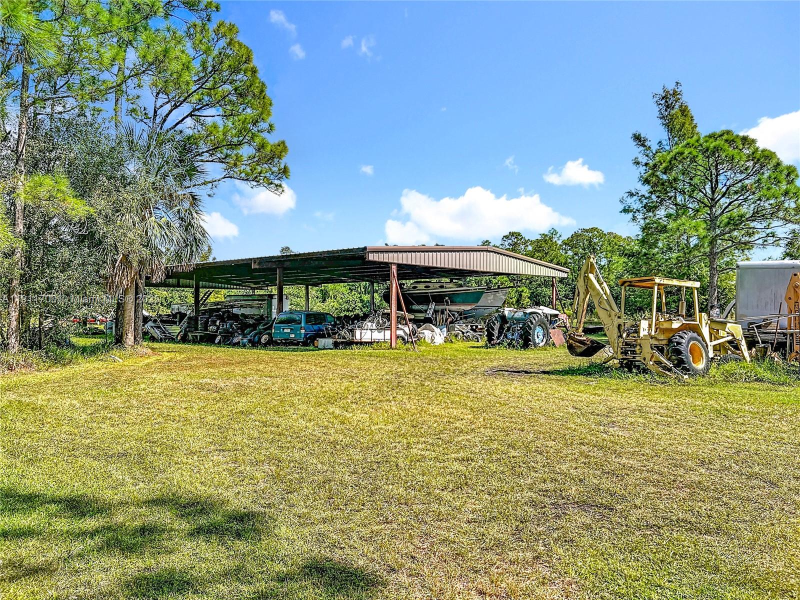 1432 Silver Lake Road LaBelle, FL 33935 - Photo 32 of 39 a view of a swimming pool with lawn chairs and plants