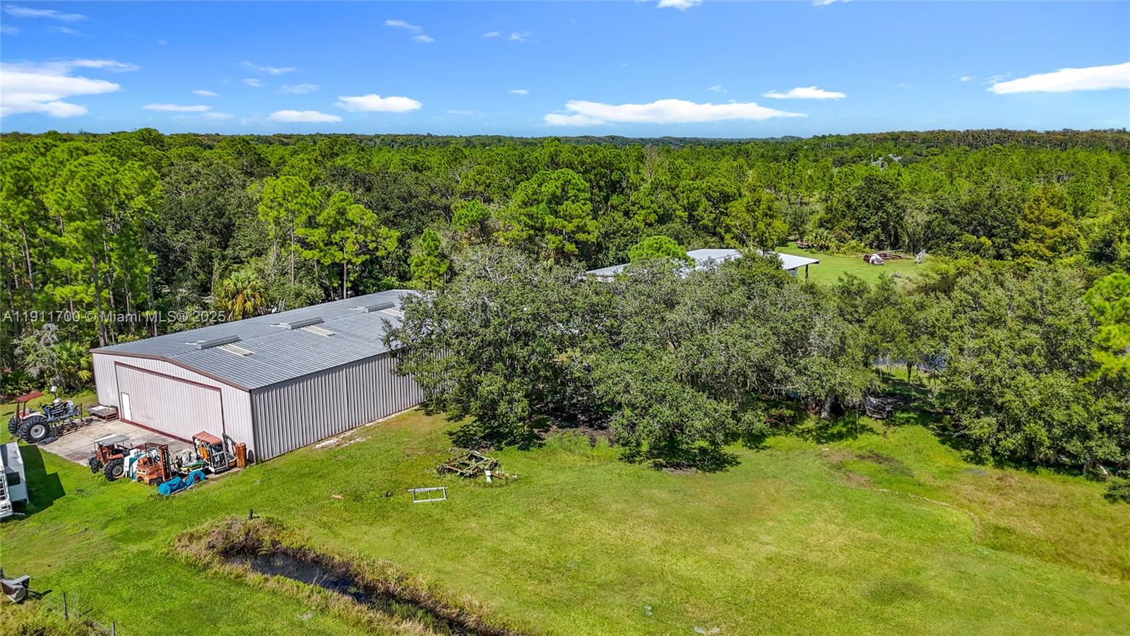 1432 Silver Lake Road LaBelle, FL 33935 - Photo 37 of 39 a view of a big yard with potted plants and large tree