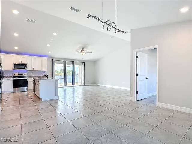 a view of an empty room with closet and a fan