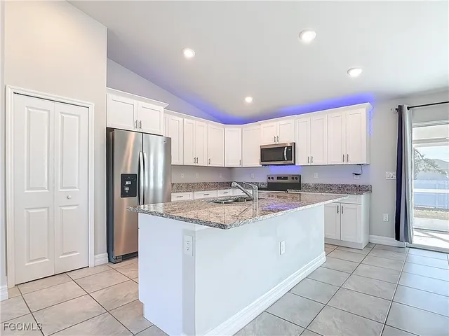 a view of an empty room with a chandelier fan