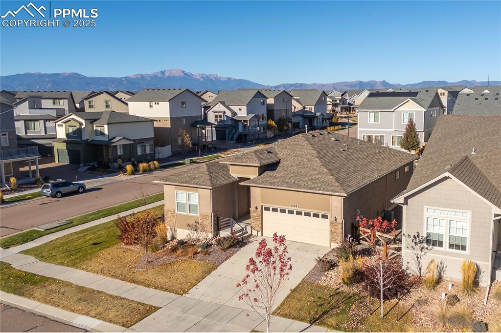 6208 Ashmore Road Colorado Springs, CO 80927 - Photo 49 of 50 View of front of home featuring concrete driveway, a mountain view, a garage, roof with shingles, and stucco siding