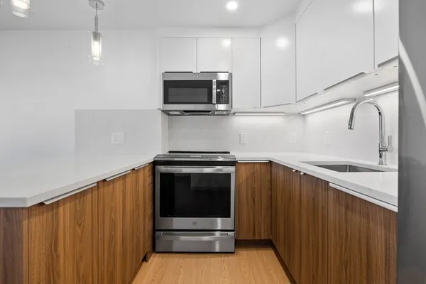 a kitchen with stainless steel appliances wooden cabinets and stove