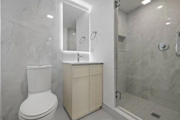 a white toilet sitting next to a bathroom sink