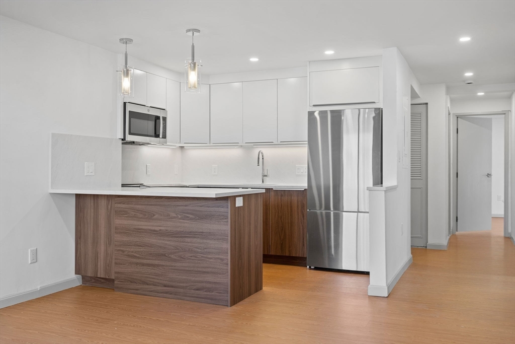 1243 Beacon Street, Unit 5A Brookline, MA 02446 - Photo 5 of 21 a kitchen with stainless steel appliances refrigerator and microwave