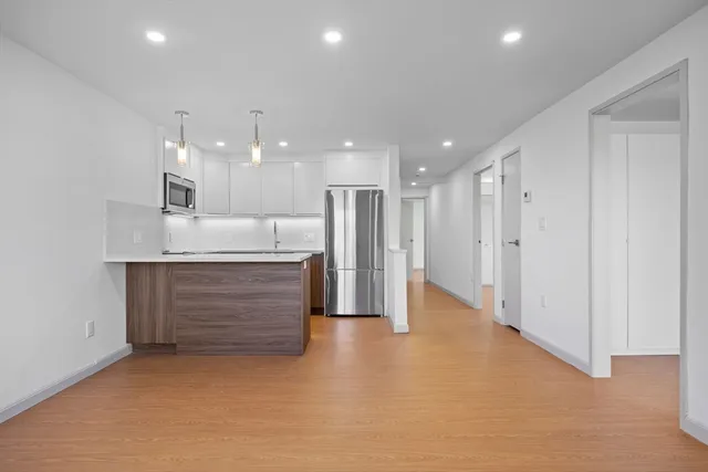 an empty room with windows and cabinet