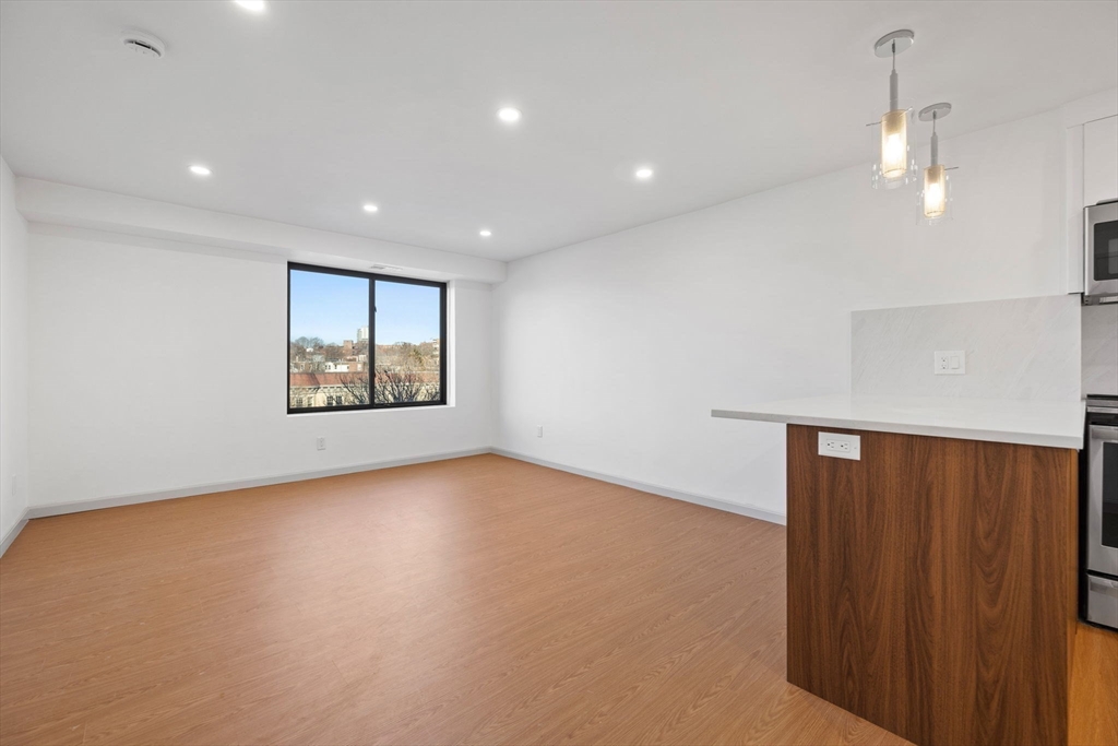1243 Beacon Street, Unit 5A Brookline, MA 02446 - Photo 7 of 21 an empty room with windows and cabinet