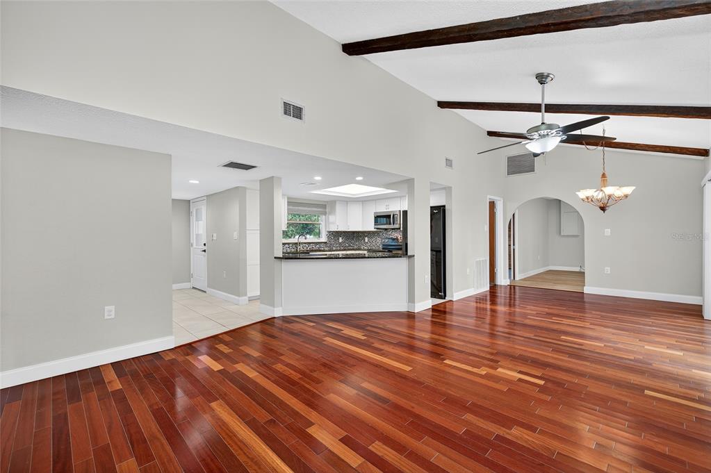 302 Leafwood Road Tarpon Springs, FL 34689 - Photo 14 of 55 a view of empty room with wooden floor and kitchen view