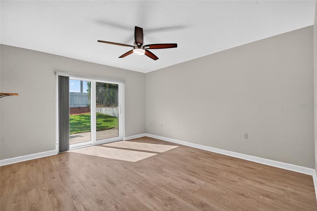 302 Leafwood Road Tarpon Springs, FL 34689 - Photo 18 of 55 a view of an empty room with wooden floor and fan