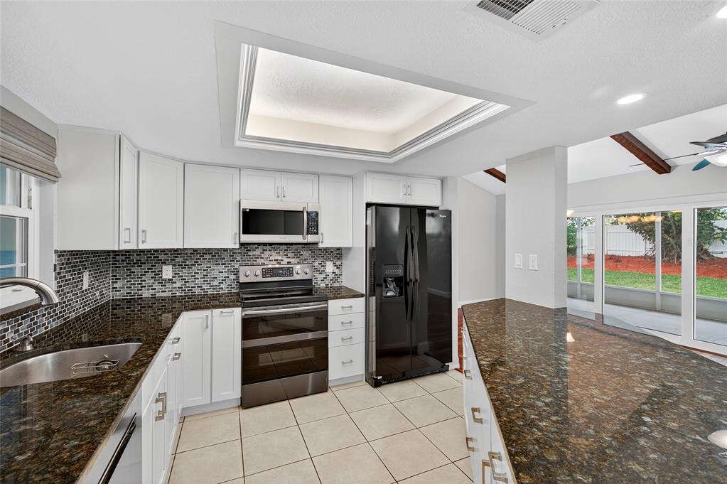 302 Leafwood Road Tarpon Springs, FL 34689 - Photo 2 of 55 a kitchen with granite countertop a refrigerator and a sink